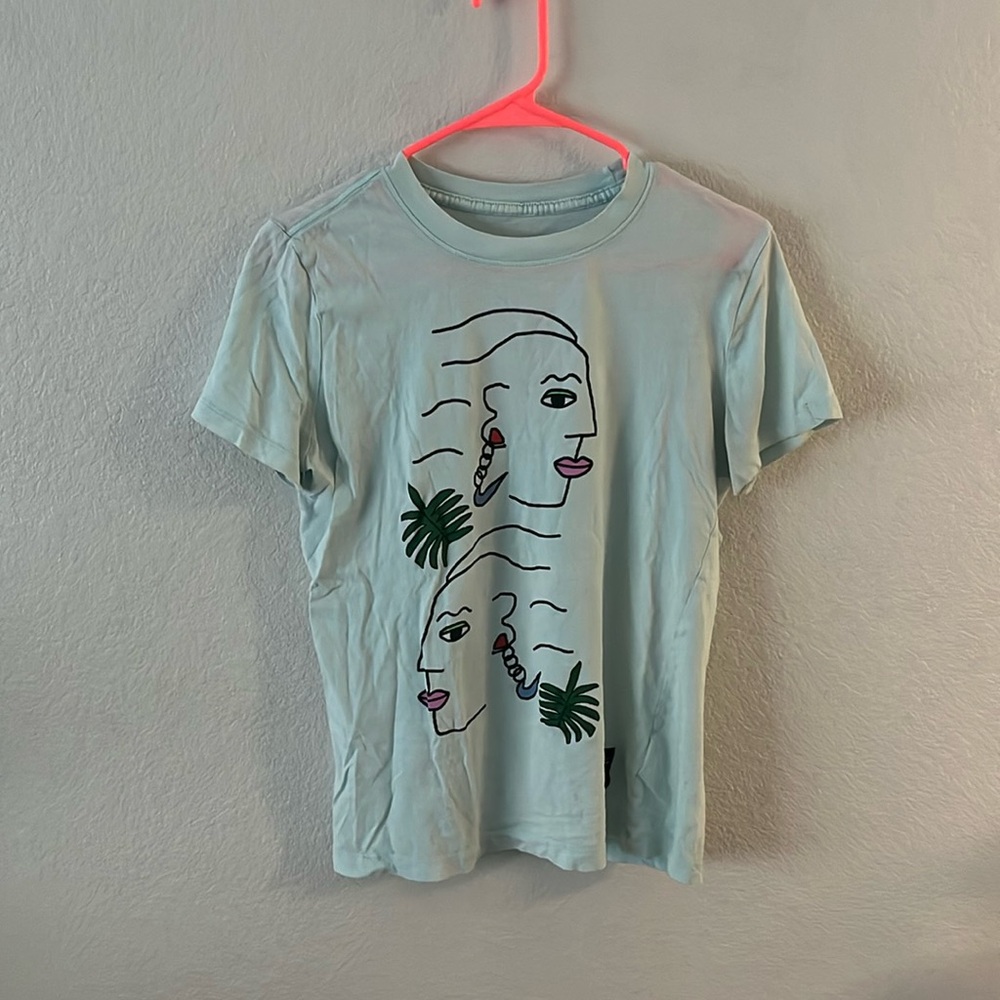 -teal nike tee with faces on them